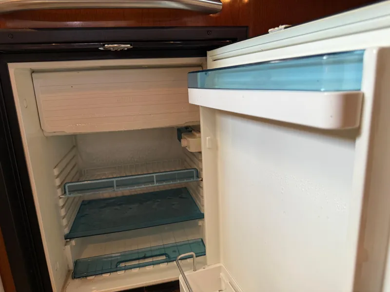 Slide: The Image of Open refrigerator inside a 2008 Sea Ray 330 Sundancer boat, showing empty shelves. - 41