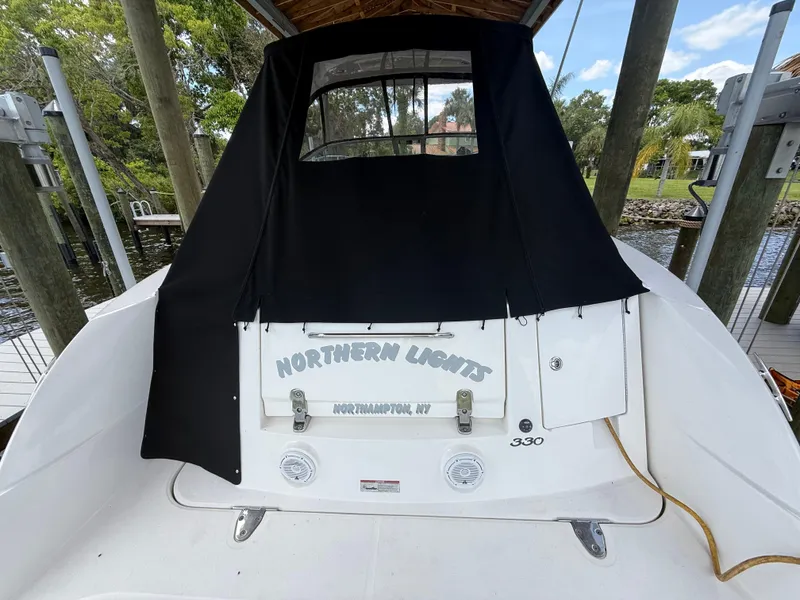 Slide: The Image of 2008 Sea Ray 330 Sundancer docked, featuring black canvas cover and "Northern Lights" name. - 6