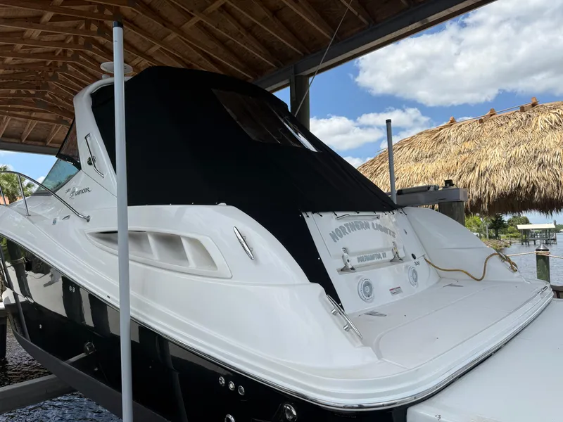 Slide: The Image of 2008 Sea Ray 330 Sundancer docked under a wooden canopy with a thatched roof nearby. - 7