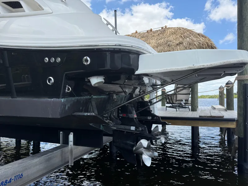 Slide: The Image of 2008 Sea Ray 330 Sundancer boat docked, showcasing stern and propellers under a clear sky. - 8