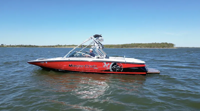 Slide: The Image of 2008 MasterCraft X45 boat on a lake with clear blue sky. - 0