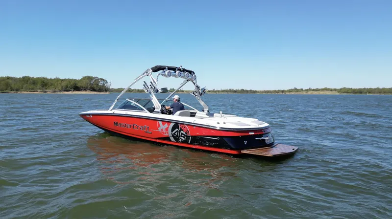 Slide: The Image of 2008 MasterCraft X45 boat on a lake under clear blue sky. - 1