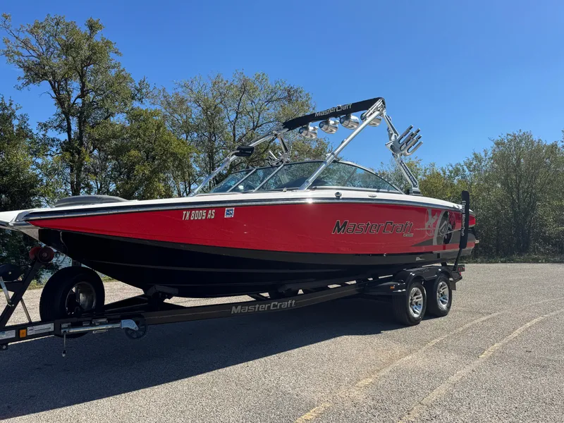 Slide: The Image of 2008 MasterCraft X45 boat on trailer, red and black, parked outdoors. - 12
