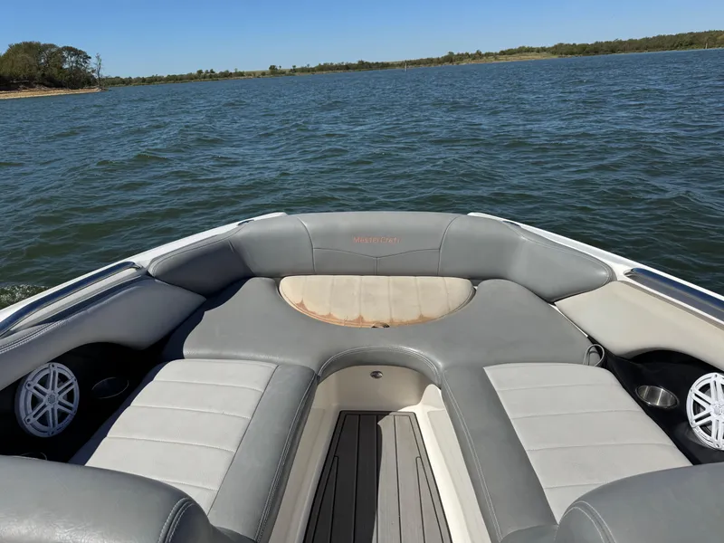 Slide: The Image of 2008 MasterCraft X45 boat interior with gray seating on a lake. - 13