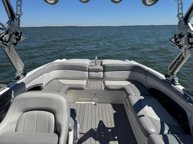 Slide: The Image of 2008 MasterCraft X45 boat interior with gray seating on a calm lake. - 14