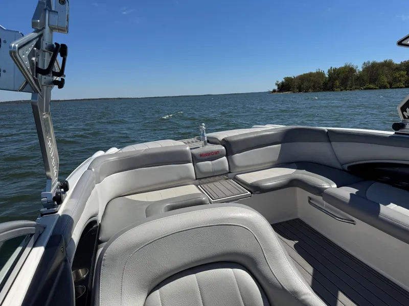 Slide: The Image of 2008 MasterCraft X45 boat interior with gray seating on a sunny lake. - 15