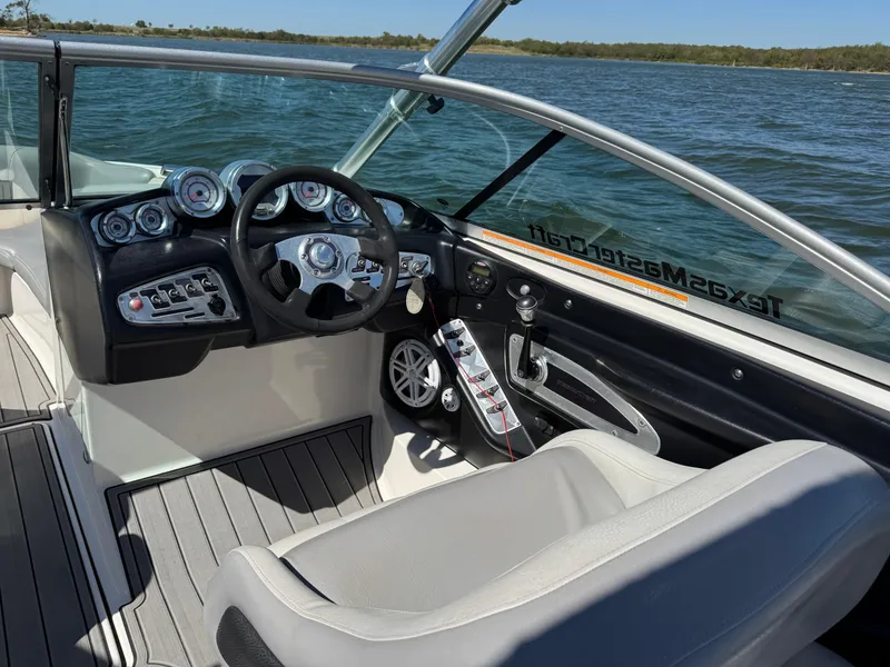 Slide: The Image of 2008 MasterCraft X45 boat cockpit with steering wheel and control panel on a lake. - 20