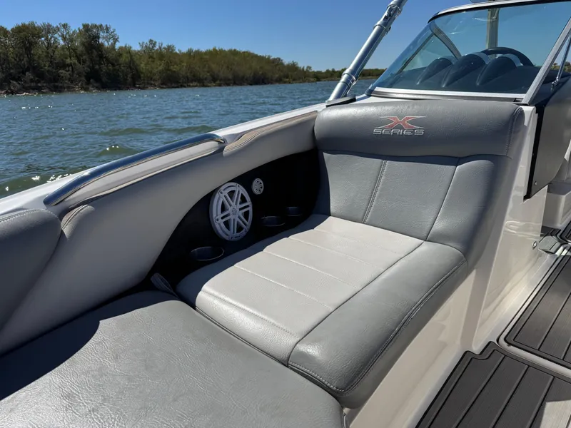 Slide: The Image of 2008 MasterCraft X45 boat interior with gray seating and speaker on a sunny day. - 23