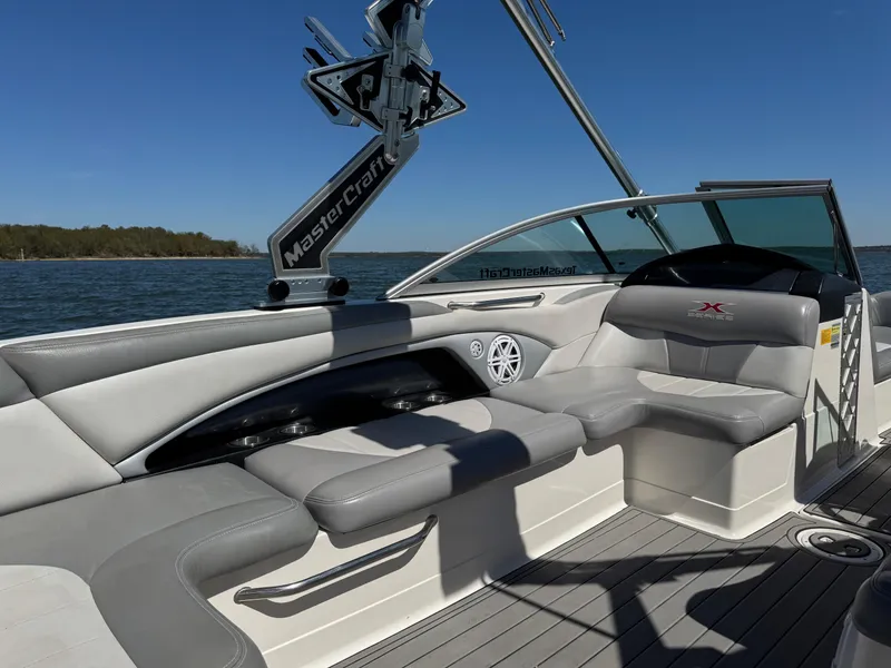 Slide: The Image of 2008 MasterCraft X45 boat interior with gray seating, on a sunny day by the water. - 27