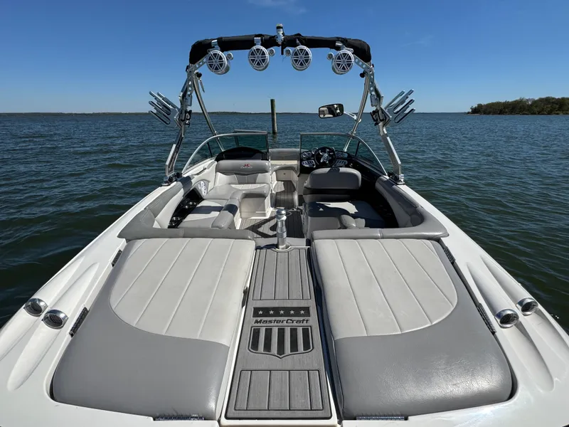 Slide: The Image of 2008 MasterCraft X45 boat with sleek seating and advanced audio system on a calm lake. - 28