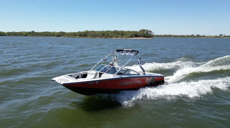 Slide: The Image of 2008 MasterCraft X45 boat cruising on a lake under clear blue skies. - 4