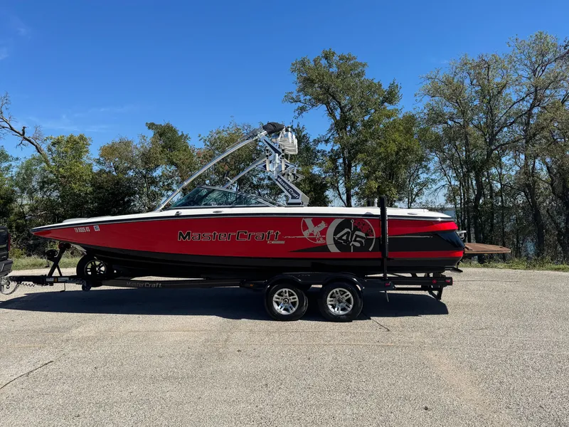 Slide: The Image of 2008 MasterCraft X45 boat on trailer, red and black design, parked outdoors. - 9