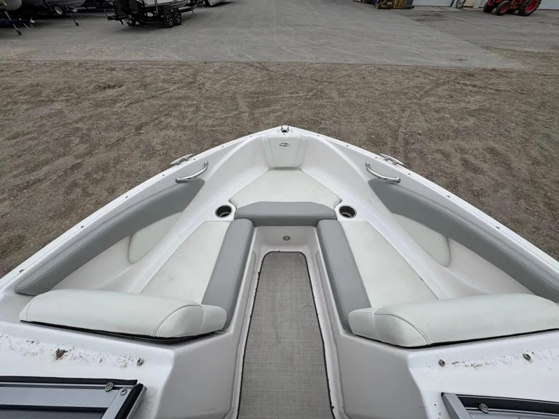 Slide: The Image of Bow seating area of a 2021 Regal 1900 ES boat, featuring white and gray upholstery. - 4