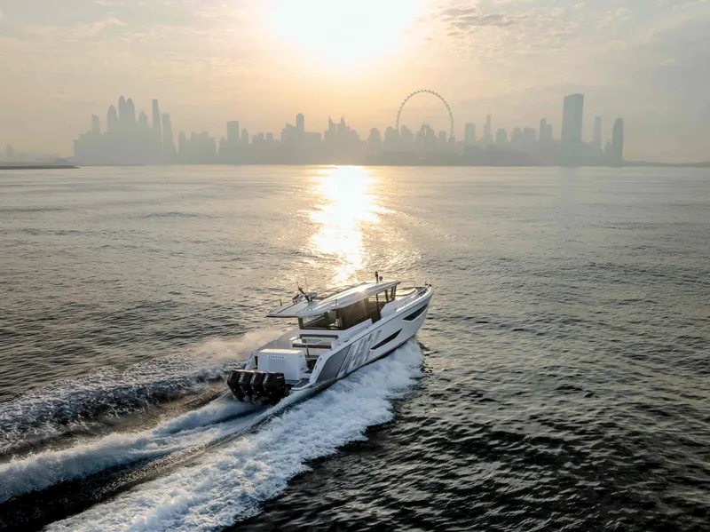 The Image of 2025 Oryx 47 LX yacht cruising at sunrise with city skyline in the background. - 0