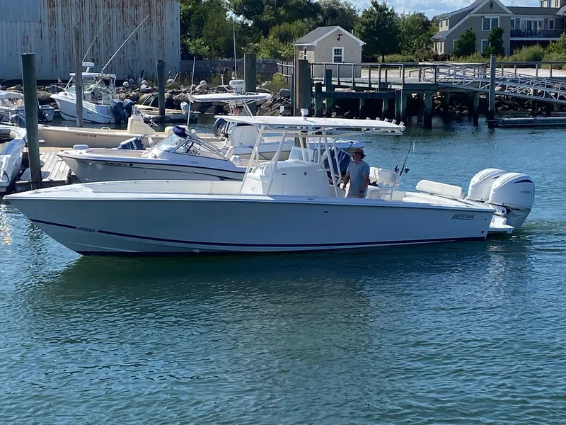 Slide: The Image of 2004 Jupiter 31 FS boat docked beside a wooden pier under clear blue sky. - 1