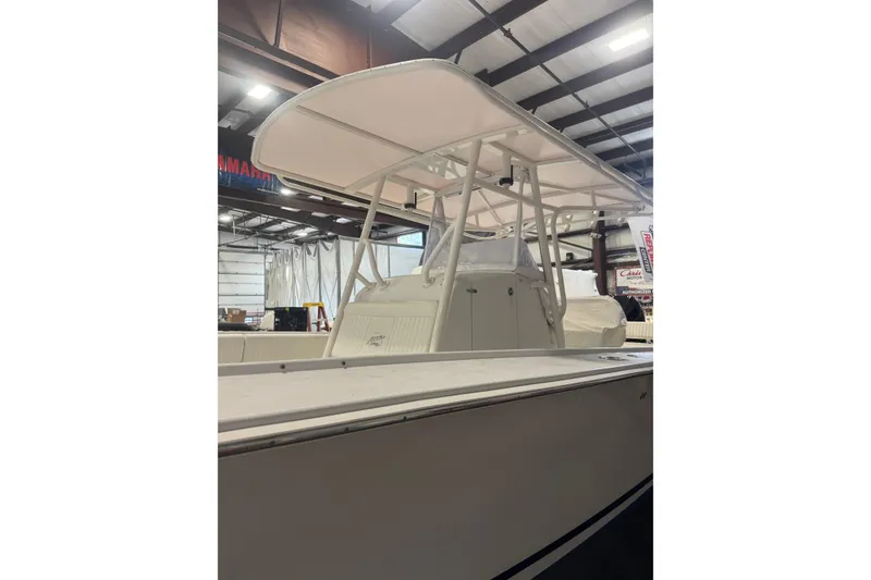 Slide: The Image of 2004 Jupiter 31 FS boat in a warehouse, featuring a sturdy T-top design. - 24