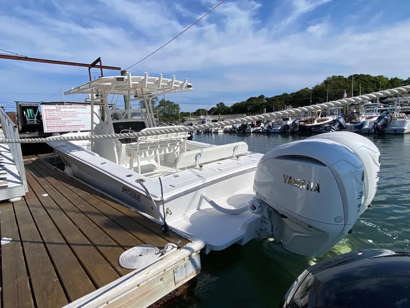 Slide: The Image of 2004 Jupiter 31 FS boat in a garage with military flags in the background. - 3