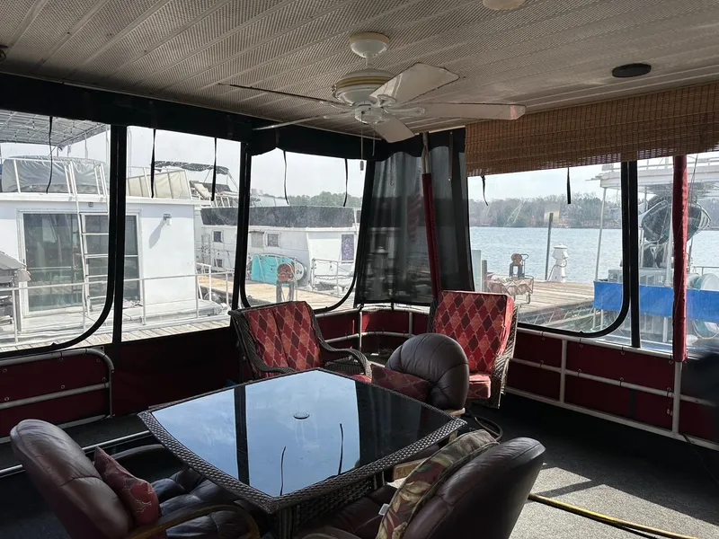 Slide: The Image of Interior of 1985 Sumerset 14x60 houseboat with seating and table, overlooking marina. - 1