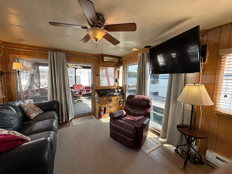 Slide: The Image of Cozy living area in 1985 Sumerset 14x60 houseboat with leather seating and large TV. - 3