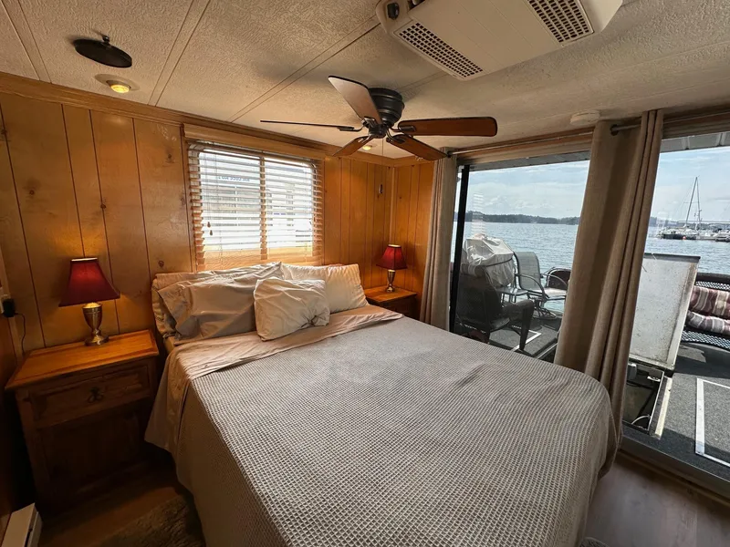 Slide: The Image of Cozy bedroom in 1985 Sumerset 14x60 houseboat with lake view and wooden interior. - 6