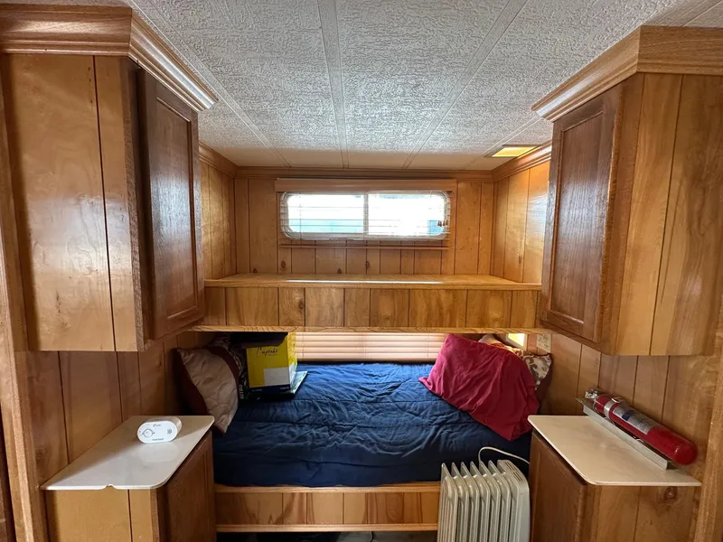 Slide: The Image of Cozy bedroom in 1985 Sumerset 14x60 houseboat with wood paneling and storage cabinets. - 8