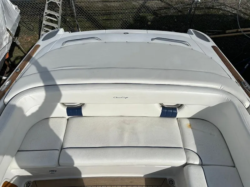 Slide: The Image of 2003 Chris-Craft 28' Corsair boat with white cushioned seating and wooden accents. - 11