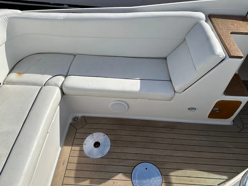 Slide: The Image of 2003 Chris-Craft 28' Corsair boat interior with white seating and wooden deck. - 12