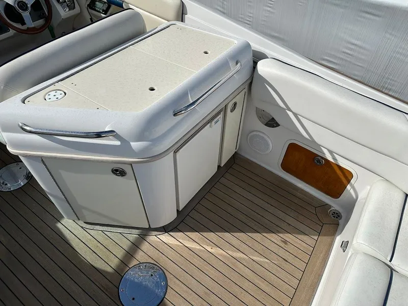 Slide: The Image of 2003 Chris-Craft 28' Corsair boat interior with white seating and wooden flooring. - 13