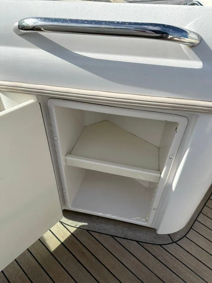 Slide: The Image of Open storage compartment on 2003 Chris-Craft 28' Corsair boat with wooden deck. - 15