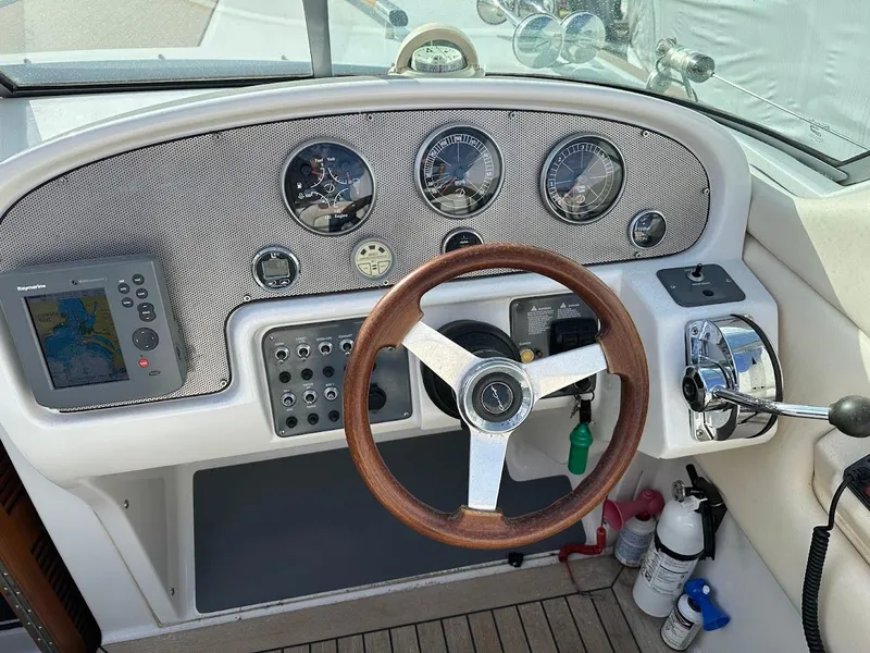 Slide: The Image of 2003 Chris-Craft 28' Corsair helm with gauges, wooden steering wheel, and navigation equipment. - 19
