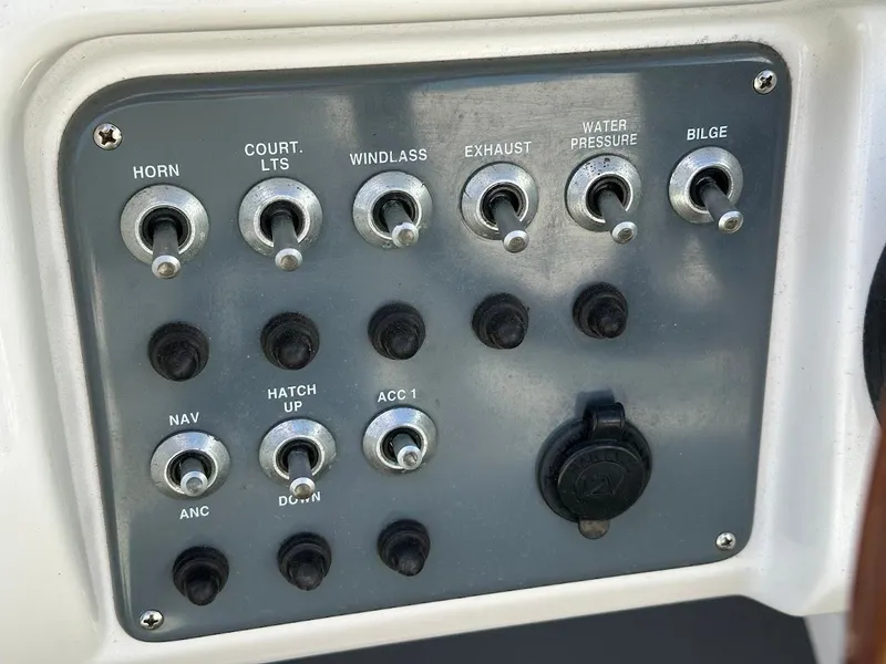 Slide: The Image of Control panel of a 2003 Chris-Craft 28' Corsair boat with labeled switches. - 22