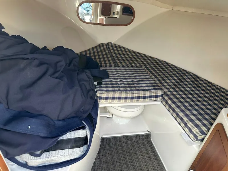 Slide: The Image of 2003 Chris-Craft 28' Corsair cabin interior with plaid cushions and storage space. - 25