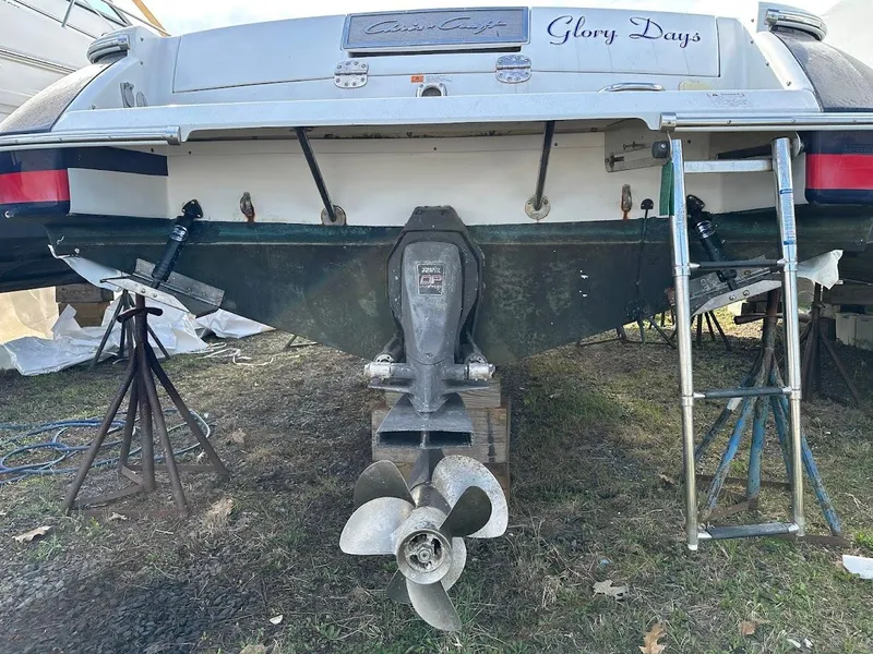 Slide: The Image of 2003 Chris-Craft 28' Corsair boat, rear view, on stands, with visible propeller and "Glory Days" name. - 32