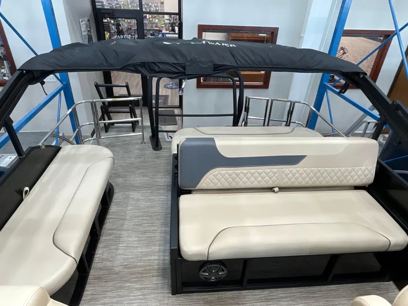 Slide: The Image of 2025 Godfrey SW2286SFLC Tritoon interior with beige seating and black canopy. - 12