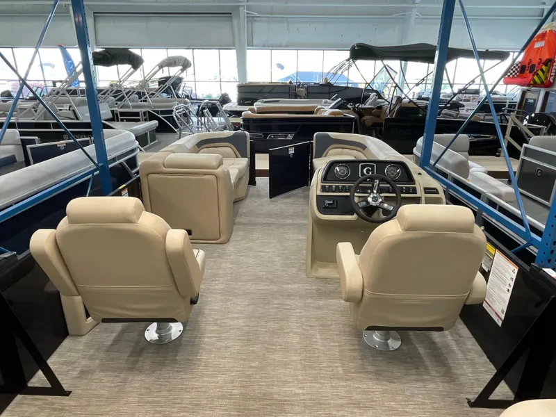 Slide: The Image of 2025 Godfrey SW2286SFLC Tritoon interior with beige seating and modern dashboard. - 18