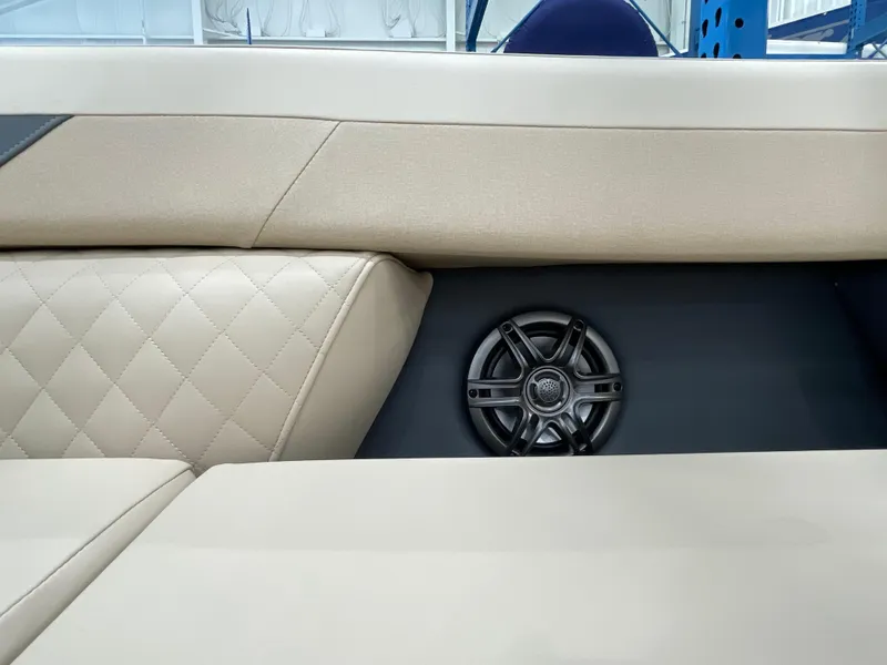 Slide: The Image of 2025 Godfrey SW2286SFLC Tritoon interior with beige quilted seating and speaker. - 22