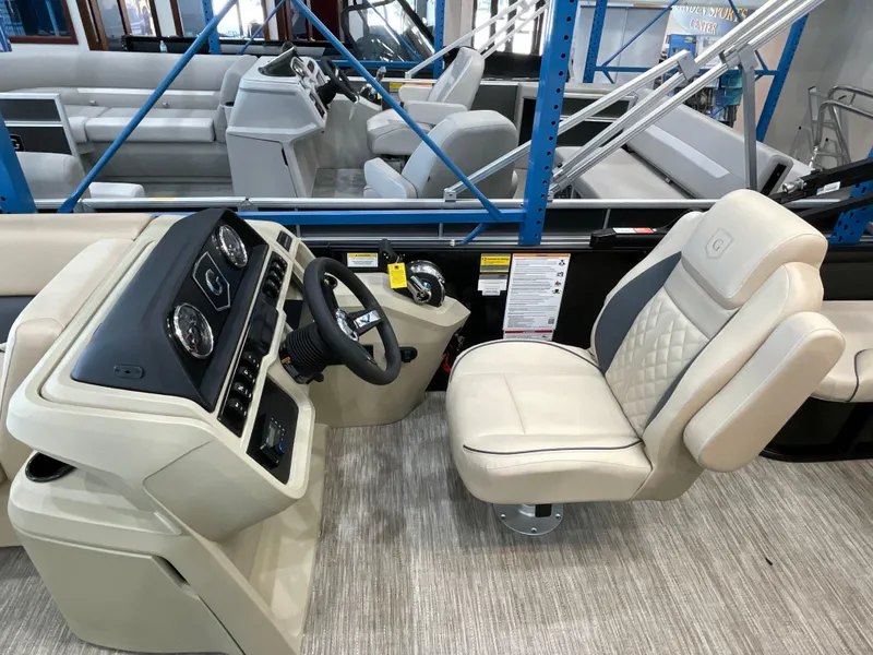 Slide: The Image of Captain's seat and console of 2025 Godfrey SW2286SFLC Tritoon boat, featuring modern controls. - 8