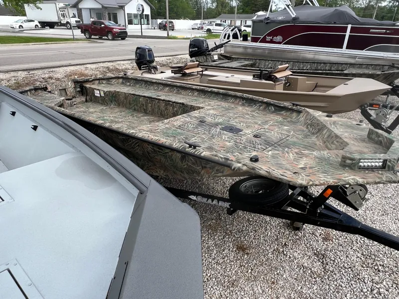 Slide: The Image of 2025 SeaArk 1960 Slayer Pro boat with camouflage design on a trailer. - 4