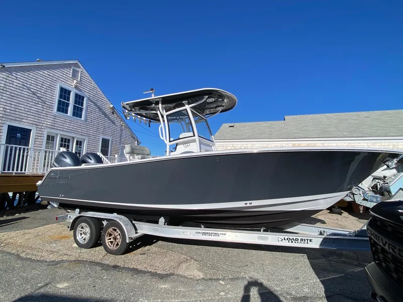 Slide: The Image of 2020 Sportsman Heritage 251 Center Console boat on trailer, parked near a house. - 0