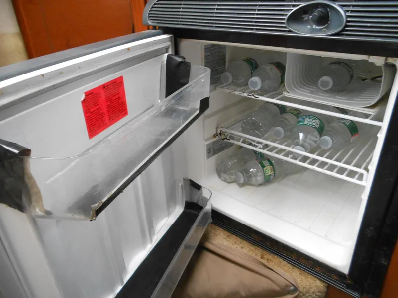 Slide: The Image of Mini fridge inside 2008 Sea Ray 260 Sundancer, stocked with water bottles. - 11