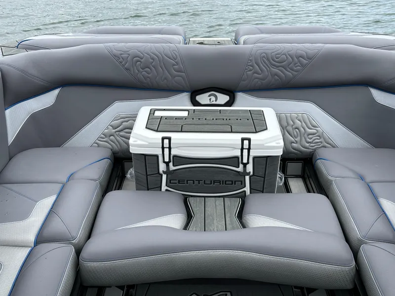 Slide: The Image of 2025 Centurion Ri245 boat interior with stylish seating and branded cooler on a lake. - 12
