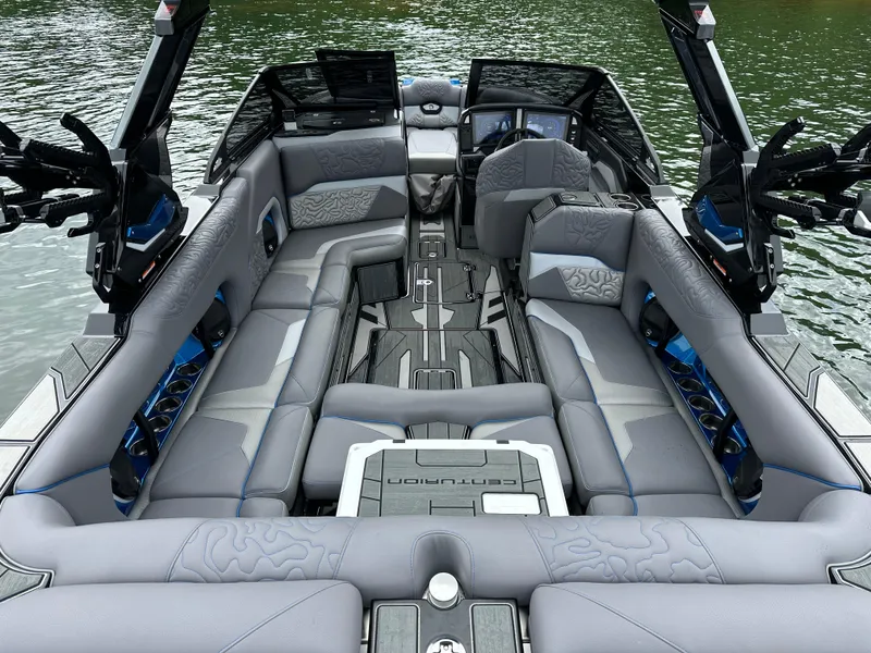 Slide: The Image of 2025 Centurion Ri245 boat interior with luxurious seating on a calm lake. - 14