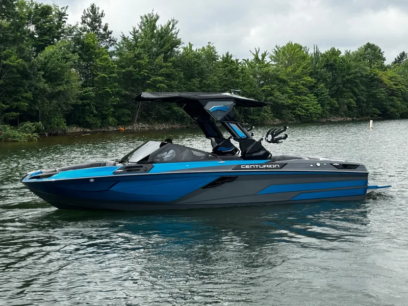 Slide: The Image of 2025 Centurion Ri245 boat on a lake, featuring sleek blue and black design. - 4