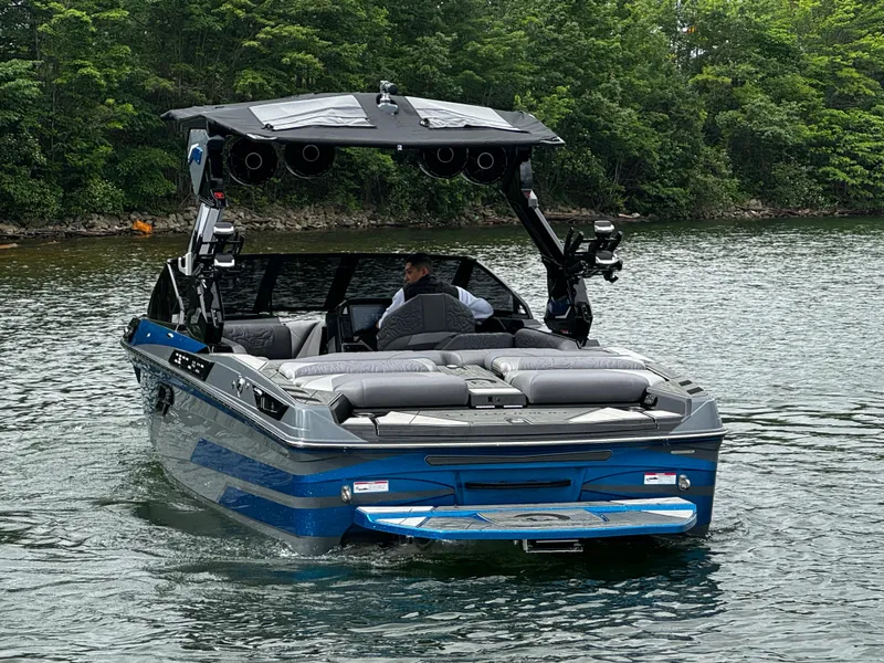 Slide: The Image of 2025 Centurion Ri245 boat cruising on a lake with lush green trees in the background. - 5