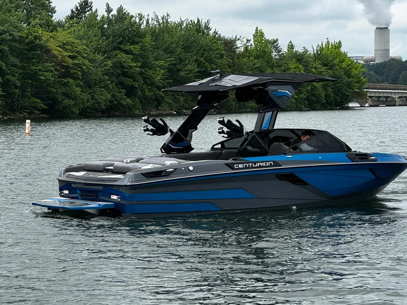 Slide: The Image of 2025 Centurion Ri245 boat on a lake, surrounded by lush greenery. - 6
