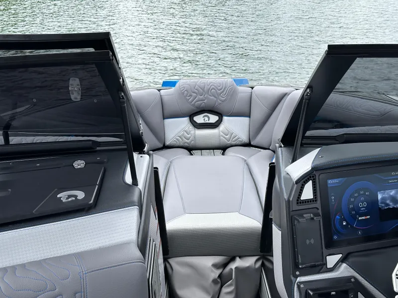 Slide: The Image of 2025 Centurion Ri245 boat interior with modern dashboard and comfortable seating on a lake. - 7