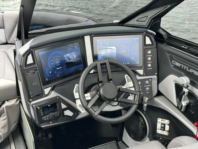 Slide: The Image of 2025 Centurion Ri245 boat dashboard with dual touchscreens and modern steering wheel. - 9