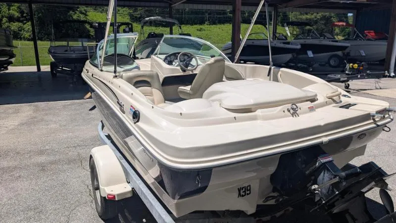 Slide: The Image of 2005 Sea Ray 180 Sport boat on trailer, parked outdoors under a canopy. - 13