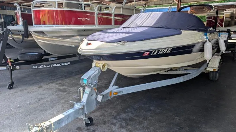 Slide: The Image of 2005 Sea Ray 180 Sport boat on trailer, covered and parked beside another boat. - 15