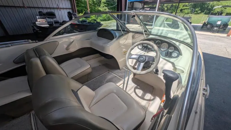 Slide: The Image of 2005 Sea Ray 180 Sport boat interior with beige seating and dashboard controls. - 6